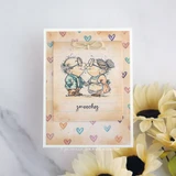 Vintage card of the kissing gray-haired couple over a heart-print background with "smooches."