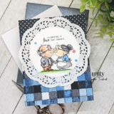 Card of the kissing couple on a doily with "Celebrating a love that endures."