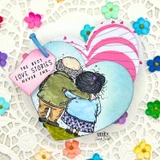 Card of the embracing couple over a blue heart with a "The best love stories never end" flag.