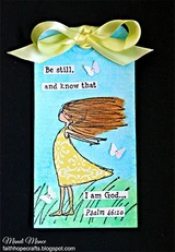 Gift tag of the girl in a yellow dress with a green bow, 'Be still, and know that I am God... Psalm 46:10.'