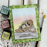 Card with a pastel blended sky and green palm-print paper, the monkeys colored in soft browns, and a strip reading Sending a little extra comfort your way.