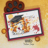 Warm gold card of the ginger grad cat clutching a diploma with red splatter and 'finally done. sheesh.'