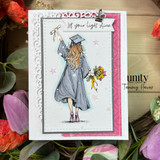 Handmade graduation card with illustrated girl in cap and gown holding diploma and bouquet, soft pastel background with star accents, layered panels, and “Let your light shine” sentiment