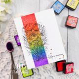 Handmade card featuring a detailed floral bouquet stamp over a vertical rainbow ink blended strip, accented with splatter details and “Hope is blooming” sentiment.
