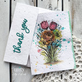 Close-up of handmade card detail featuring stamped grass and ink splatter on textured torn paper layers.