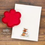 Card with cuddling dog and cat and red paw-shaped ink pad.