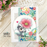 Card with skunk holding pink flower on floral patterned background with twine and button.