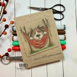 Kraft card with a fluffy dog lounging in an orange hammock strung between two posts and 'Wishing you a little peace in your day.'
