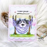Card with the fluffy dog dozing in a purple hammock on a soft green scene with 'You deserve a pause.'