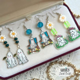 Three pairs of ghost-themed handmade earrings featuring daisies, flower crowns, and beach-chair ghosts with colorful bead accents.