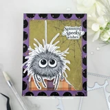 Halloween card with a fuzzy googly-eyed spider dangling over green and plaid patterned papers on a purple frame, 'spinning spooky wishes.'