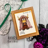 Highland cow draped in a white ghost bedsheet holding a jack-o'-lantern pail, stamped on a kraft card reading 'So spooky-ish!' and 'Happy hauntings.'
