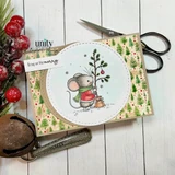 Kraft card topped with tree print paper and a stitched circle, the mouse setting up a small decorated tree beside a sack, stamped 'Bring on the merry.'