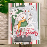 Snowbert card with the snowman in a green stocking cap, green sweater and orange scarf holding a candy cane, a red merry Christmas die cut and white snowflakes on striped holiday paper