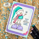 Purple matted card of Snowbert in a long teal stocking cap, pink striped scarf and big lavender boots holding up a snowflake, with 'wishing you a flurry of happy moments.'