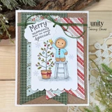 Green plaid banner card with twine: the gingerbread boy in aqua icing on a stool placing a star on a potted tree with red baubles, sentiment 'Merry moments make the season special'.