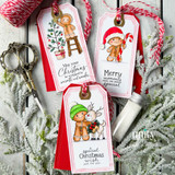 Three Baking Spirits Bright gift tags from Unity Stamp Co on red cardstock: the gingerbread boy trimming a little tree from a stool, the gingerbread boy in a Santa hat with a candy cane, and the gingerbread boy hugging a reindeer, one tag reading "Merry moments make the season special".