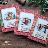 Three cranberry and snowflake holiday cards with postage-stamp frames and twine: the mouse coloring at her craft table, the mouse carrying heart cards, and the mouse posting a letter, with 'Handmade happiness headed your way.'