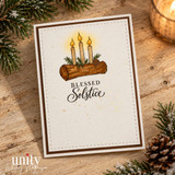 Celebrations of Light card from Unity Stamp Co: the Yule log with three lit candles and pine sprigs on a cream panel with a brown border, with "Blessed Solstice".