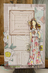 Soft vintage card with a girl in a pink floral maxi skirt stamped over an embossed door panel with white blooms.