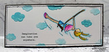 Slim white panel with soft blue die cut clouds and the girl colored in pink and blue mid swing, Imagination can take you anywhere. stamped small at the left.