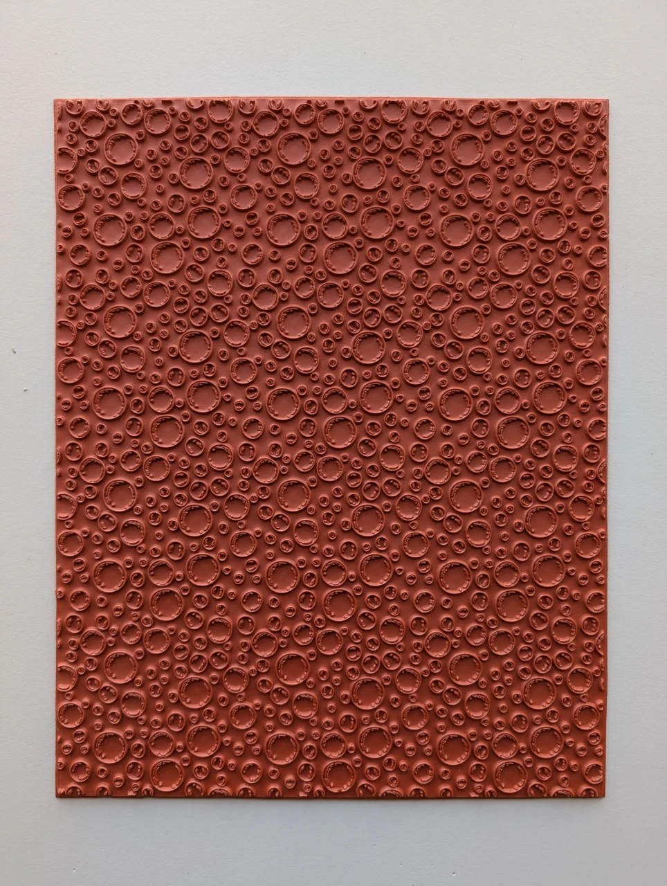 Full red rubber pottery texture mat patterned with open circular rings in varied sizes.