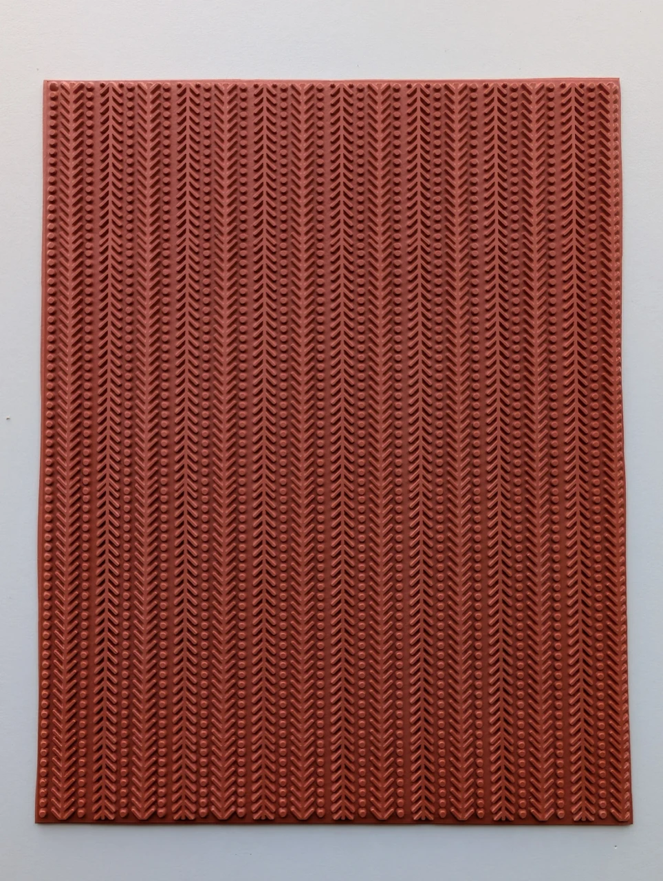 Full red rubber pottery texture mat with vertical herringbone lines and rows of raised dots.
