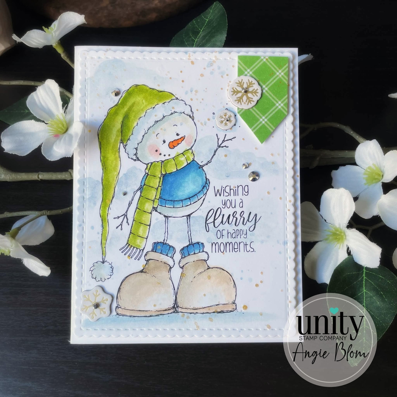 Snowbert card with the round snowman in a lime green stocking cap, blue sweater and green striped scarf, tan boots, and 'wishing you a flurry of happy moments.' on a speckled watercolor panel