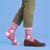 AI-generated styling image of Fuck You Unicorn Socks — worn, with shoes