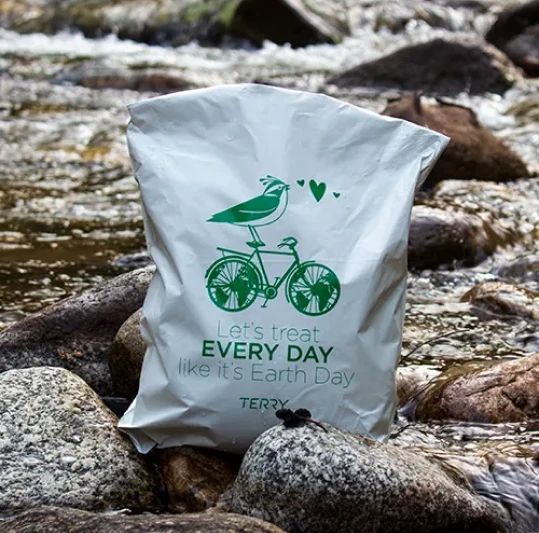 Custom white poly mailer made with recycled content and printed with a green design