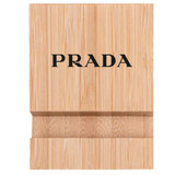 A bamboo phone holder in a natural wood finish featuring a logo on the front.