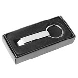 A drink bottle opener in a sleek silver finish, stored in a black box with a soft interior. It features a keyring attachment.