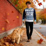 A unisex winter acrylic cotton jacquard sweater in blue and white, worn by a man walking a dog among autumn leaves.