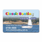 A rectangular fridge magnet with rounded corners featuring a sailing scene and a vibrant logo at the top.