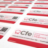 Glossy red and white dome stickers featuring a logo and QR code, arranged on a white surface.