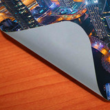A corner of a grey gripper coaster reveals a vibrant city skyline printed underneath.