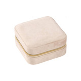 A square velvet jewellery organiser in a soft beige colour with a gold zipper.