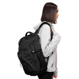 A black Fitzroy Backpack featuring multiple pockets and a mesh side compartment, worn by a person in a grey hoodie.