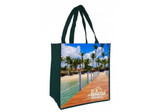 A green tote bag featuring a scenic beach design with palm trees and a wooden boardwalk, including a logo.