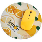 A round mouse pad in beige with lemon graphics and a yellow computer mouse on top. Features a logo.