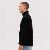 A black polar fleece full zip jacket displayed on a model. Features a high collar and a side view.
