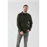 A man in a green checkered button-up shirt with long sleeves stands against a plain background, smiling.