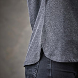 A grey women's polo shirt featuring side slits and a classic design, showcasing textured fabric.