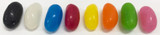 A row of jelly beans in various colours, including black, white, blue, red, yellow, orange, green, and pink.