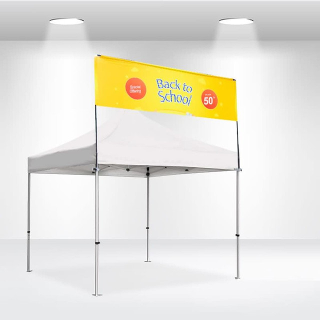 A white square tent with a yellow banner featuring a logo. The tent has a sturdy frame and is set up indoors.