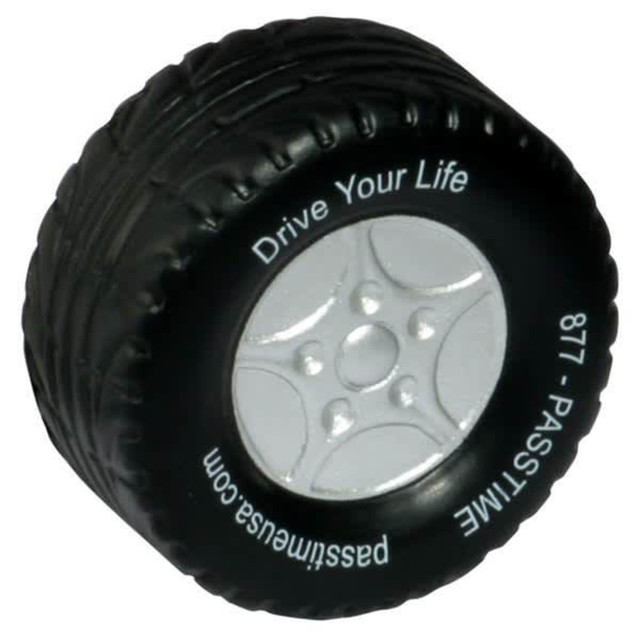 A black tire-shaped stress reliever with a silver wheel design and a logo on the side.