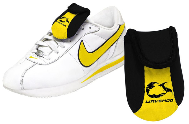 A shoe wallet in black and yellow, designed to attach to a white sneaker. It features a logo.