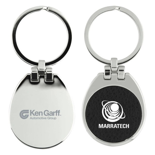 A metallic keychain with a circular ring and a flip top, featuring a textured black surface on one side and logos on both sides.