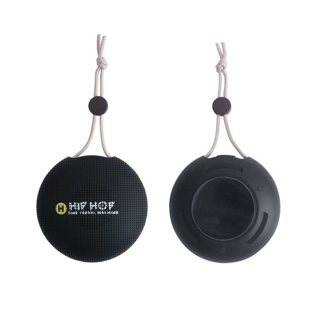 A round, black portable waterproof Bluetooth speaker with a hanging strap and a logo displayed on the front.