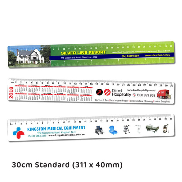 Flat plastic rulers in green, red, and white, featuring various branding and measurements, 30 cm in length.